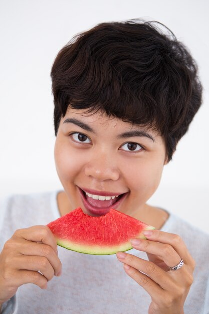 Sorrindo jovem mulher asiática comendo melancia