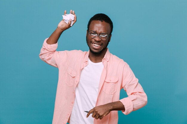 Sorrindo lágrimas de papel jovem afro-americano isolado em fundo azul