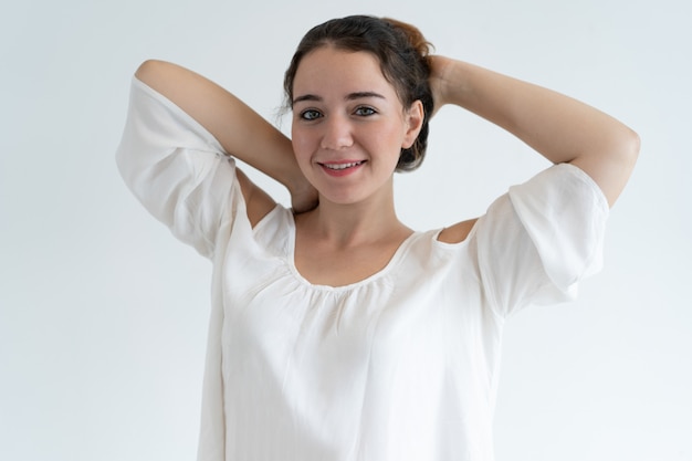 Sorrindo linda mulher segurando as mãos atrás da cabeça