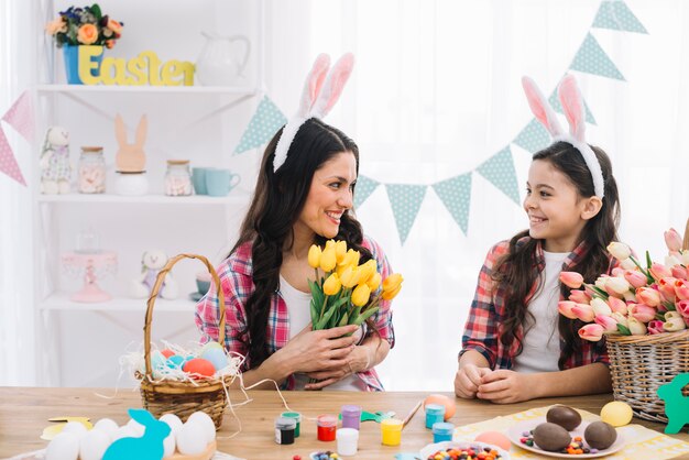 Sorrindo mãe e filha comemorando o dia de Páscoa em casa