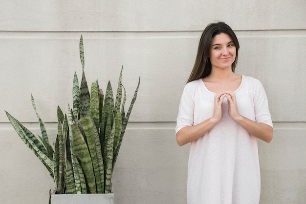 Foto grátis sorrindo, mulher, ficar, perto, verde, houseplant