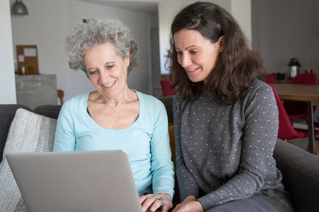 Sorrindo, mulher idosa, e, dela, filha, navegar computador portátil