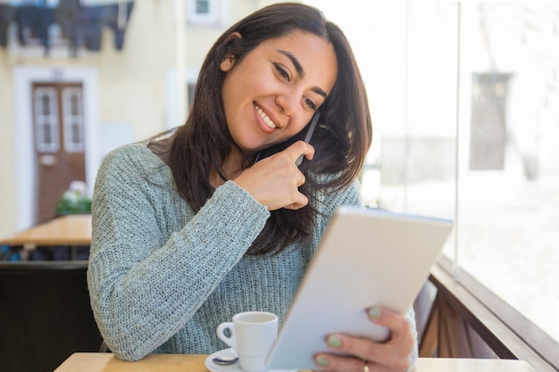 Sorrindo, mulher jovem bonita, usando, smartphone, e, tabuleta