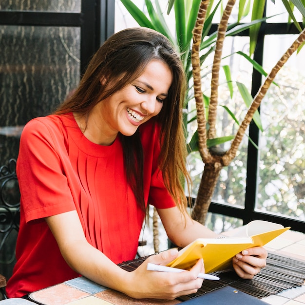 Sorrindo, mulher jovem, livro leitura, em, restaurante