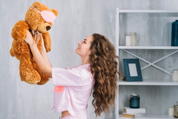 Sorrindo, mulher jovem, segurando, brinquedo macio