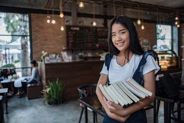 Sorrindo, mulher jovem, segurando, livros