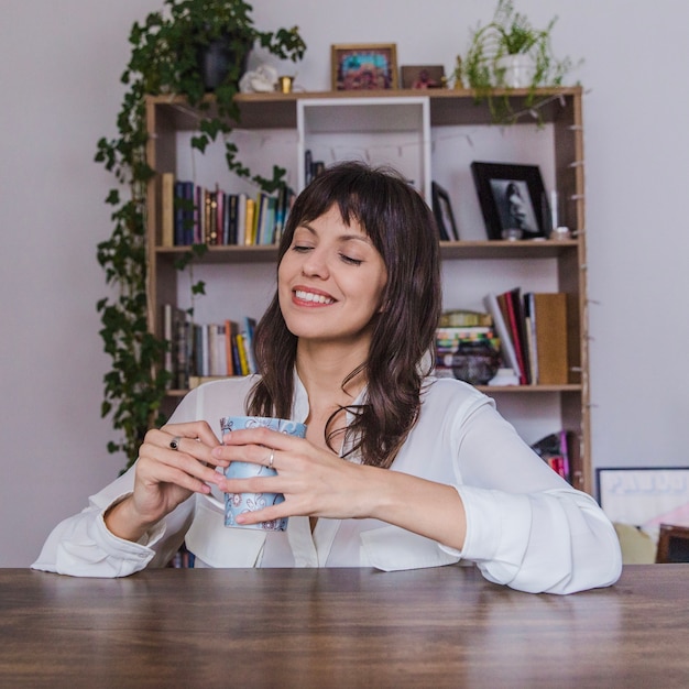 Sorrindo mulher na mesa com café