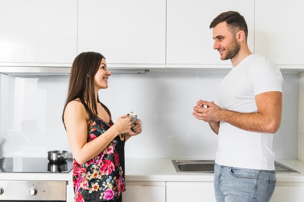 Foto grátis sorrindo, par jovem, xícara café segurando, em, mão, olhando um ao outro