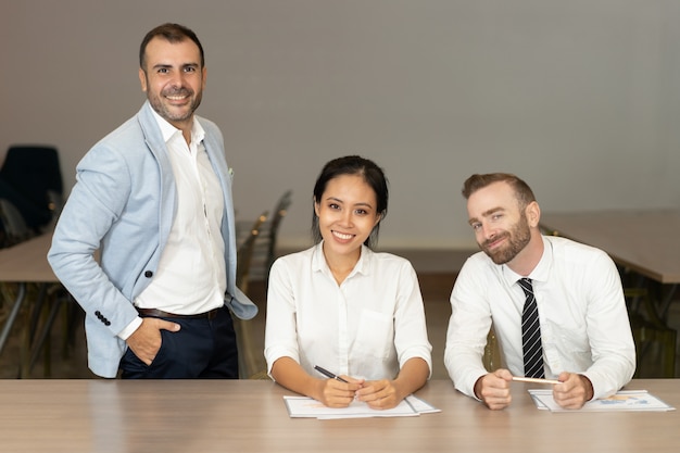 Sorrindo, pessoas negócio, posar, escrivaninha, em, escritório