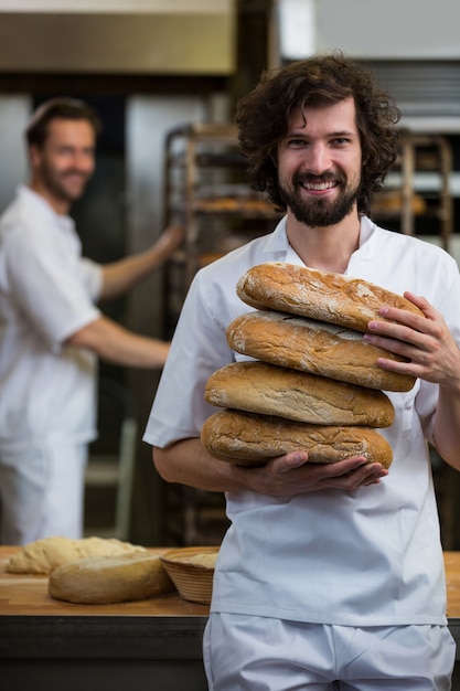 Sorrindo pilha realização padeiro de pães assados