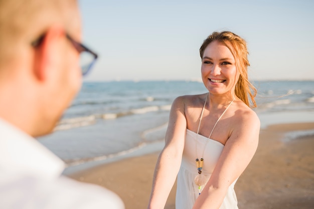 Sorrindo, retrato, de, um, mulher jovem, desfrutando, com, seu, namorado, em, praia