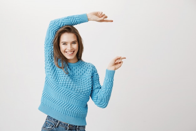 Foto grátis sorriso atraente, mulher feliz, apontando os dedos direito