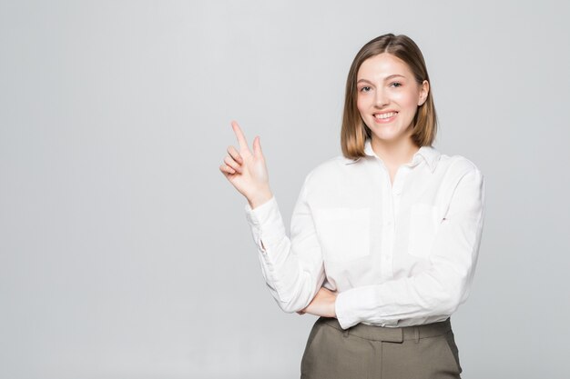 Sorriso de mulher de negócios apontando o dedo para o espaço vazio da cópia isolado sobre o branco