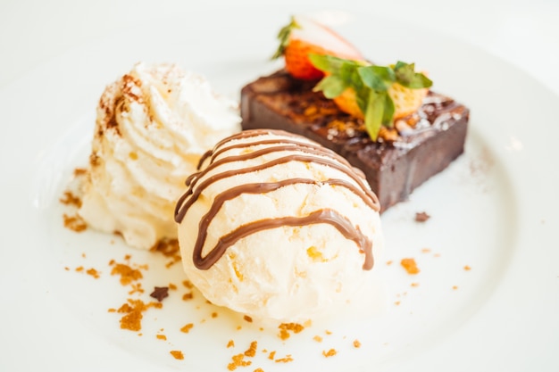 Foto grátis sorvete de baunilha com bolo de brownie com morango em