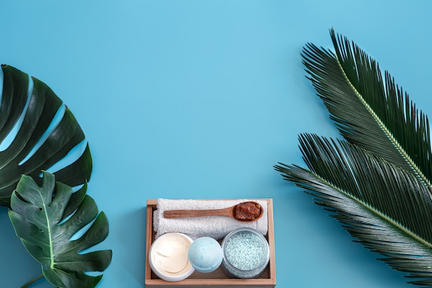 Foto grátis spa. artigos de higiene corporal em azul com folhas tropicais.