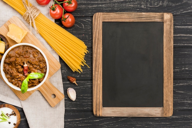 Foto grátis spaghetii bolonhesa ingredientes e quadro-negro
