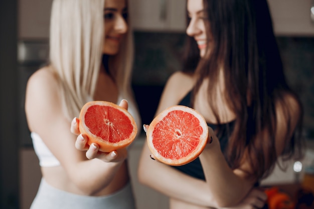 Sports girlss em uma cozinha com frutas