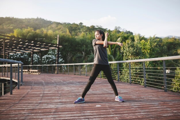 Sportswoman que estica os braços