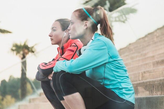 Sportswomen descansando em escadas