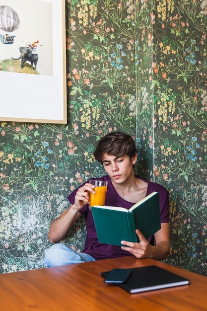 Suco bebendo masculino e livro de leitura