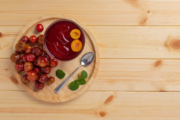 Suco de ameixas frescas na superfície de madeira.