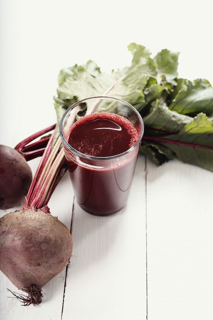 Foto grátis suco de beterraba na mesa de madeira branca