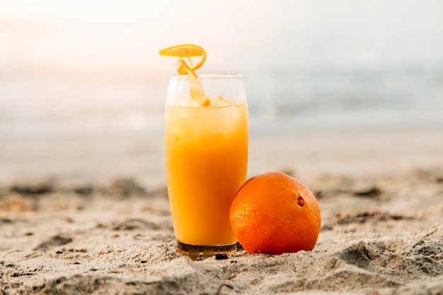 Suco de laranja em pé na areia