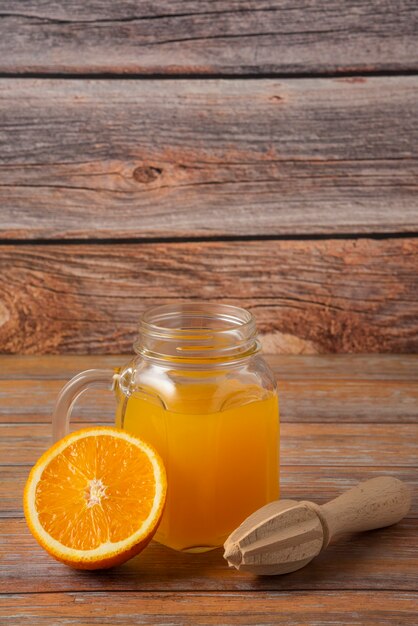 Suco de laranja em uma jarra de vidro sobre a mesa de madeira