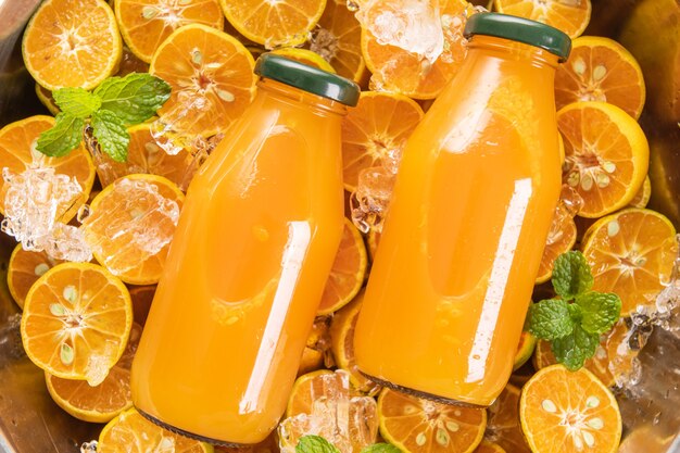 Suco de laranja fresco em frasco de vidro com frutas frescas, hortelã. foco seletivo.