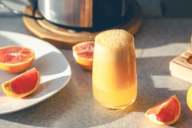 Suco de laranja fresco em um copo fechado na mesa da cozinha