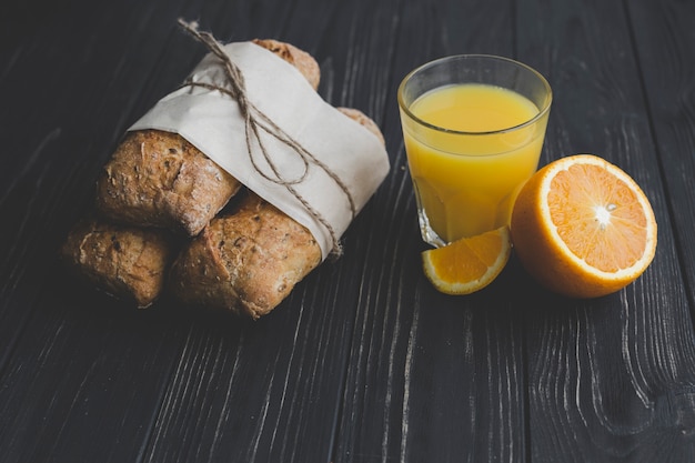 Foto grátis suco de laranja perto de pãezinhos