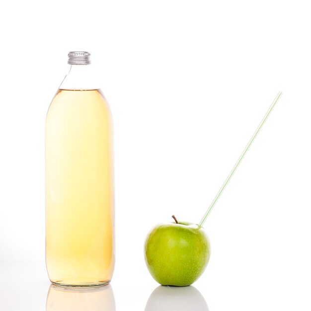 Suco de maçã em frasco de vidro e maçã verde com canudo