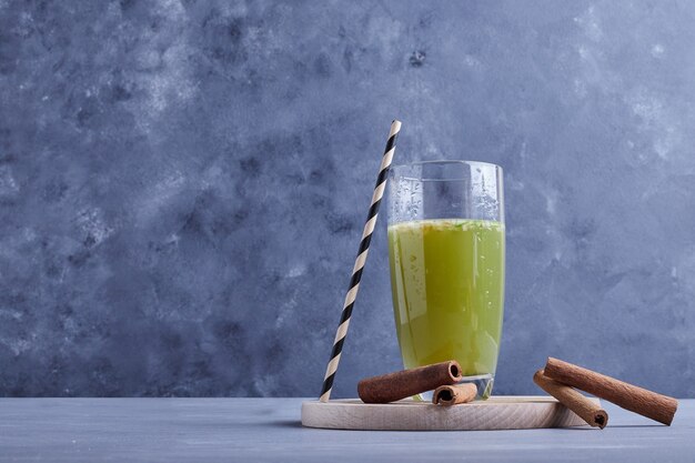 Suco de maçã verde em uma bandeja de madeira.