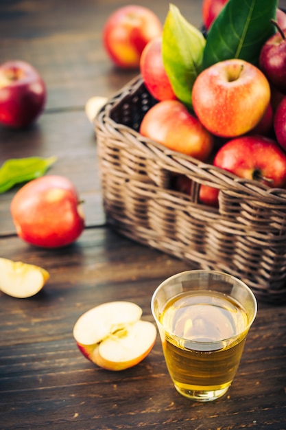 Suco de maçãs em vidro com maçã no cesto