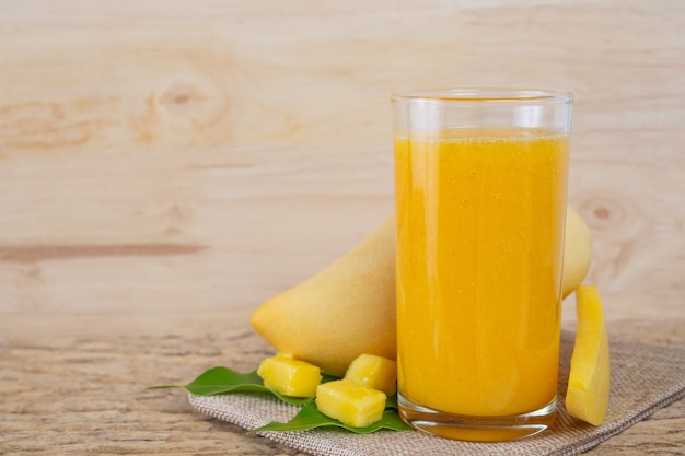 Suco de manga na mesa do assoalho de madeira.