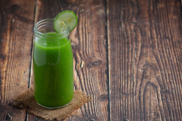 Suco de pepino fresco em uma jarra com fundo de madeira escura