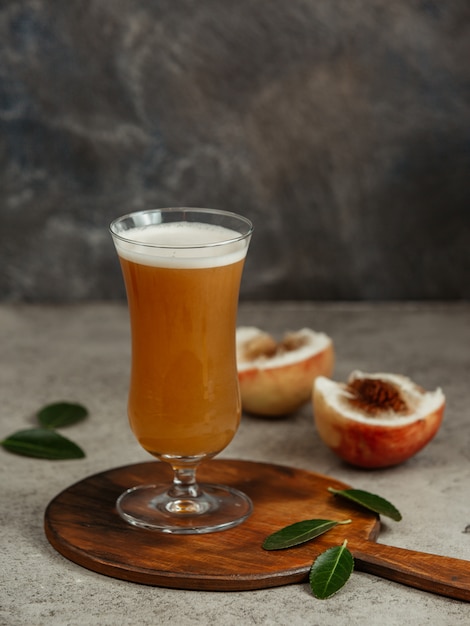 Suco de pêssego e pêssegos em cima da mesa