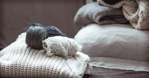 suéter de malha com bolas de lã, um conceito de calor e conforto, hobby, plano de fundo, closeup
