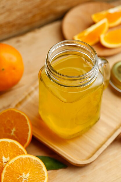 Sumo de laranja e laranjas na mesa de madeira retro