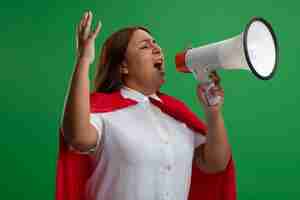 Foto grátis super-heroína de meia-idade zangada com os olhos fechados falando no alto-falante e levantando a mão isolada sobre fundo verde
