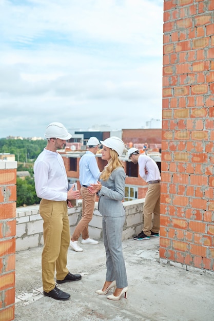 Supervisora sorridente se comunicando com um capataz ao ar livre