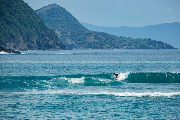 Surfista em uma onda azul.