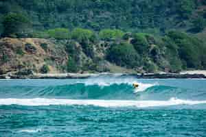 Foto grátis surfista em uma onda azul.