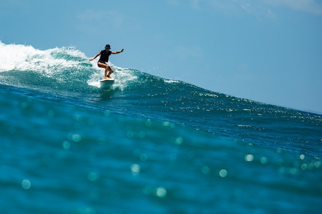 Surfista em uma onda azul.