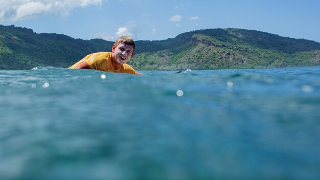 Surfista em uma onda azul.