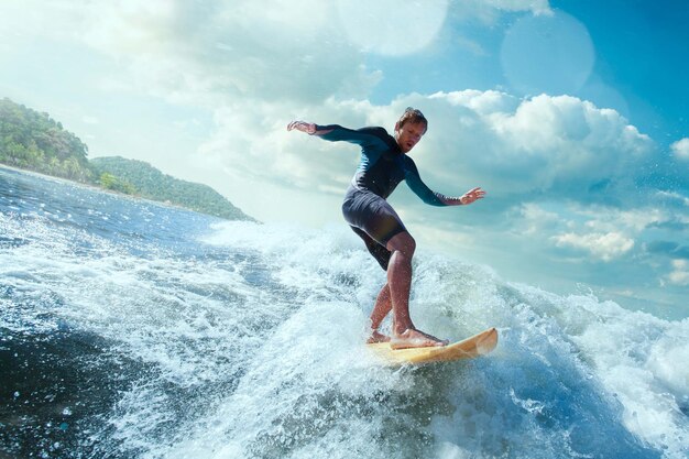 Surfista na onda do oceano azul sendo barreado