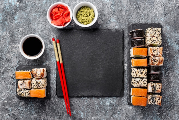 Sushi de leigos maki plana pauzinhos e molho de soja com ardósia em branco