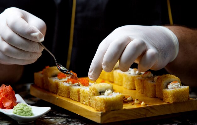 Sushi de peixe fresco com caviar vermelho em cima da mesa