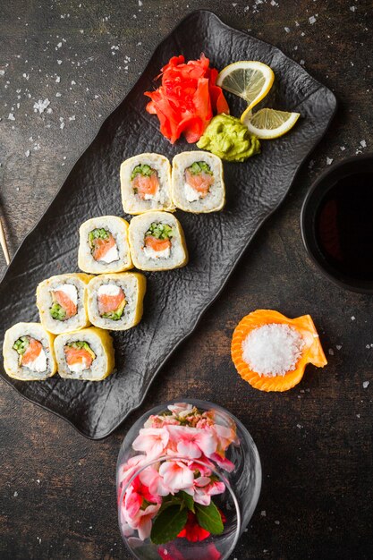 Sushi de vista superior com gengibre em conserva e wasabi e molho de soja no prato escuro
