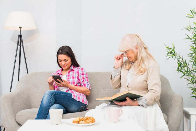 Suspeito mãe espiando sua filha adulta procurando mensagens em um smartphone